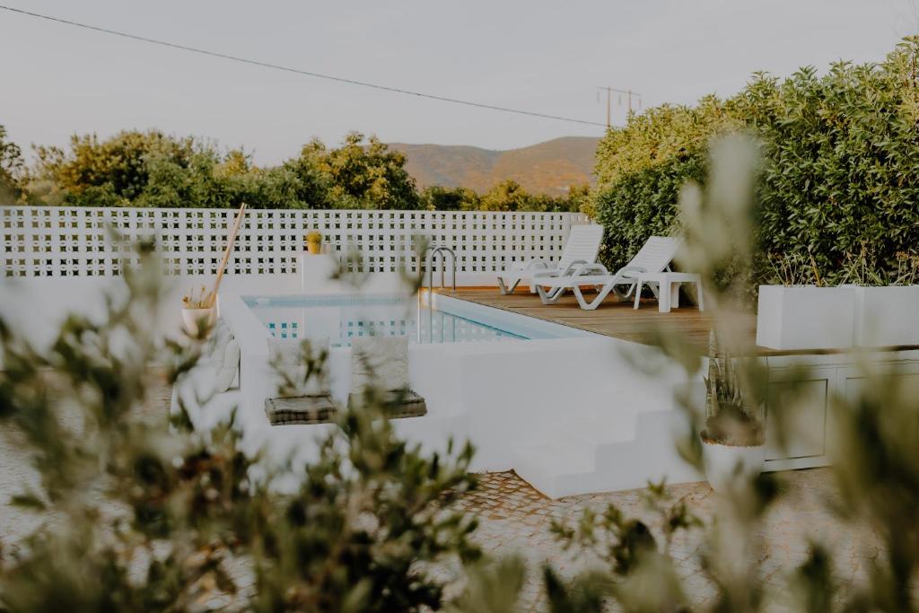 a backyard with a swimming pool and a fence at Casa Lavadeira - VINHAS de NEXE in Faro