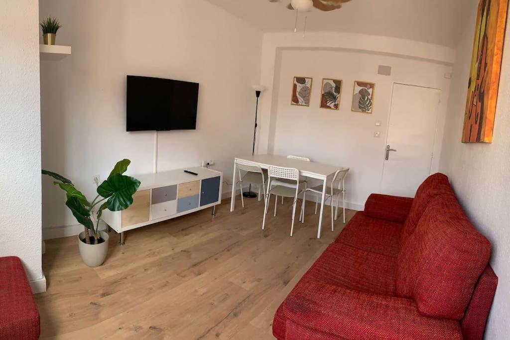 uma sala de estar com um sofá vermelho e uma mesa em Cozy 3bd near vibrant Valencia em Paiporta