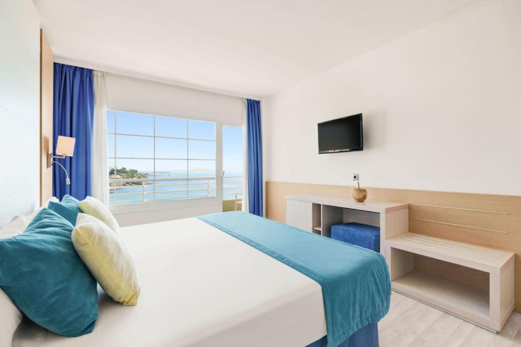 sypialnia z łóżkiem i dużym oknem w obiekcie Hotel Agua Beach "Adults only" w miejscowości Palma Nova