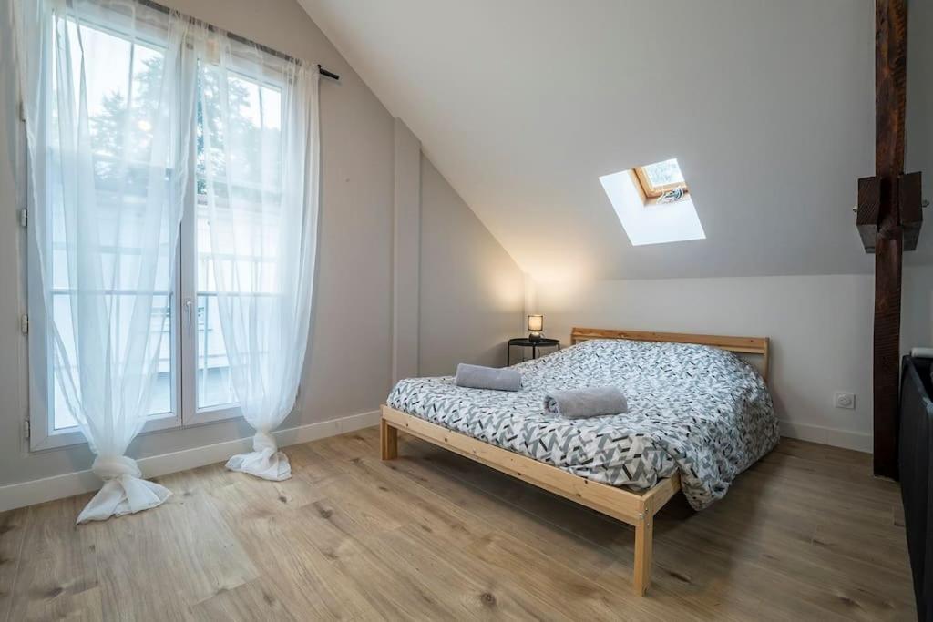 une chambre avec un lit et une grande fenêtre dans l'établissement Le Refuge Palois, à Pau