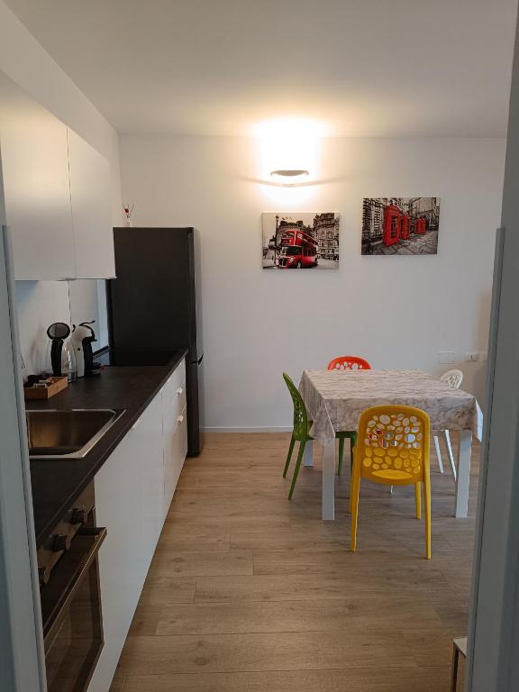 a kitchen with a table and yellow chairs in a kitchen at Eden house in Lecco