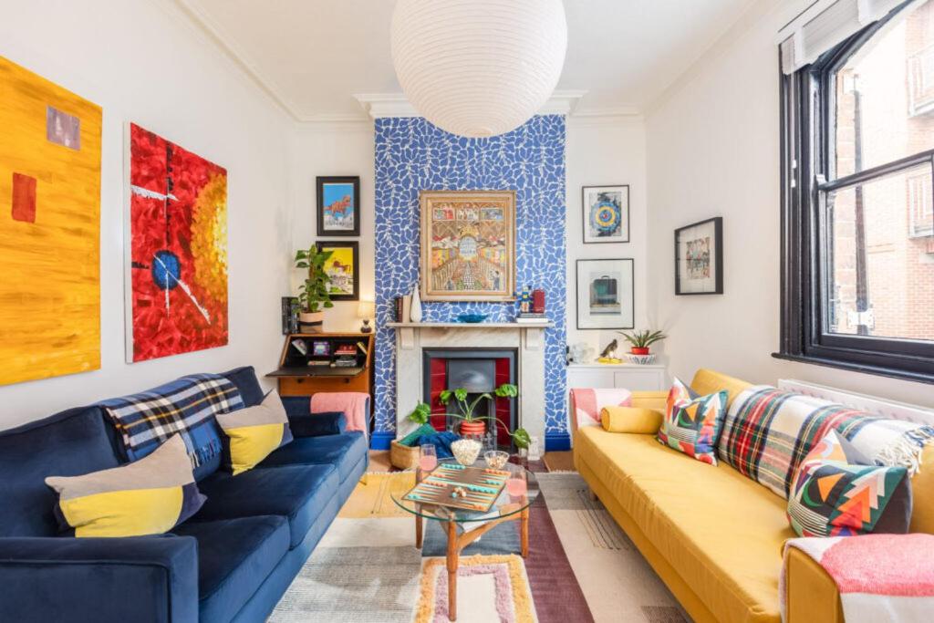 ein Wohnzimmer mit einem Sofa und einem Kamin in der Unterkunft Menagerie House Luxury City Cottage, Walk Score 98 in York