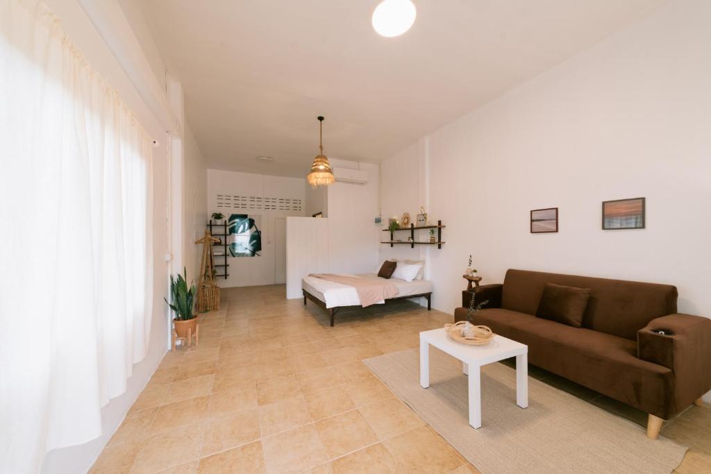 a living room with a couch and a table at Homely Home Khao lak in Khao Lak