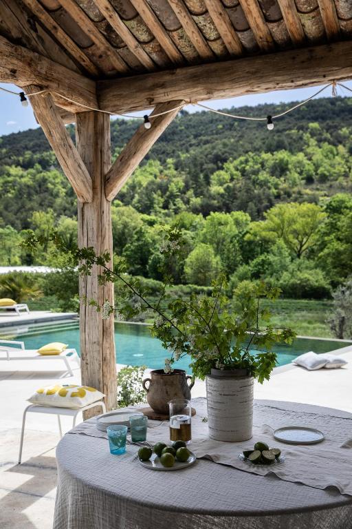- une table avec un bol de fruits et une vue sur la piscine dans l'établissement La Grange de Fer - Maison de caractère piscine privée, à Saint-Ferréol-Trente-Pas