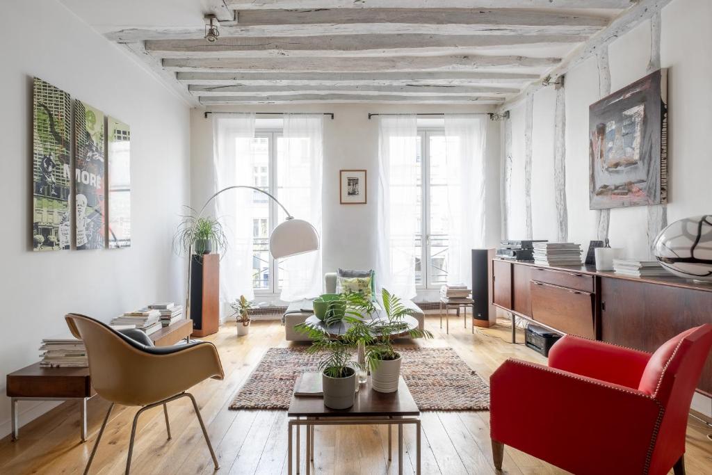 - un salon avec des murs blancs et des chaises rouges dans l'établissement Veeve - Bright Beams, à Paris