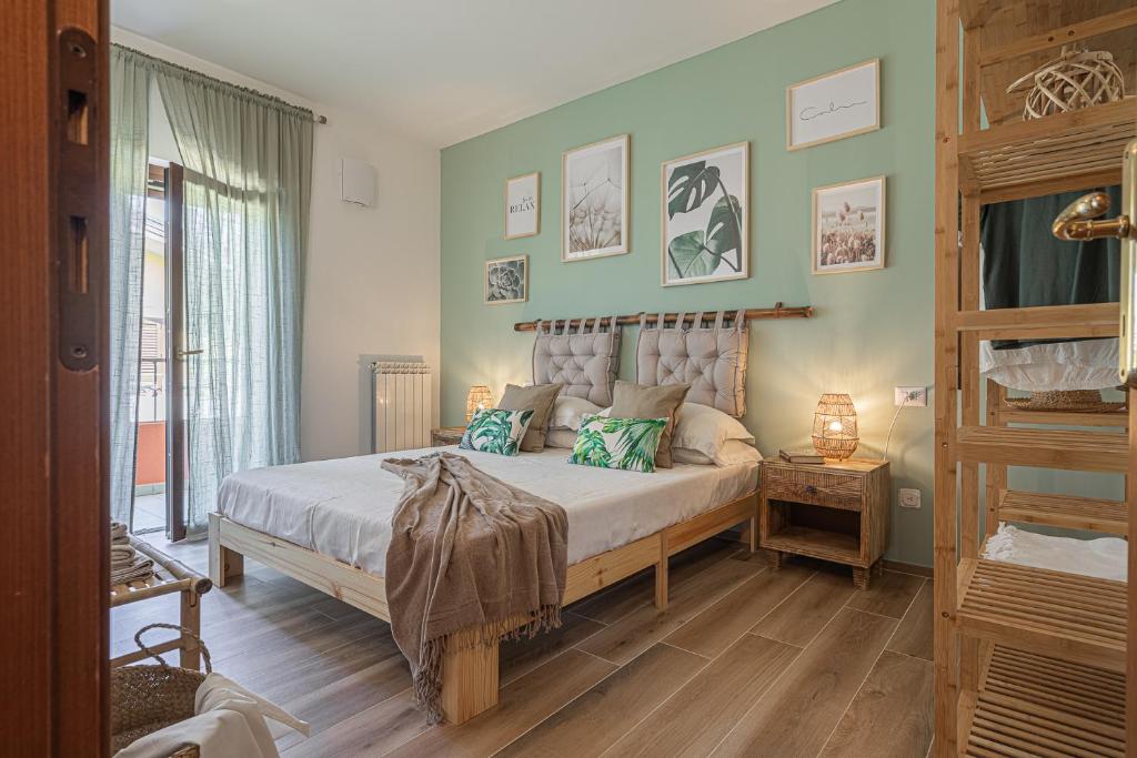 a bedroom with a large bed with green walls at Dolce Vita Family Apartment in Sirmione
