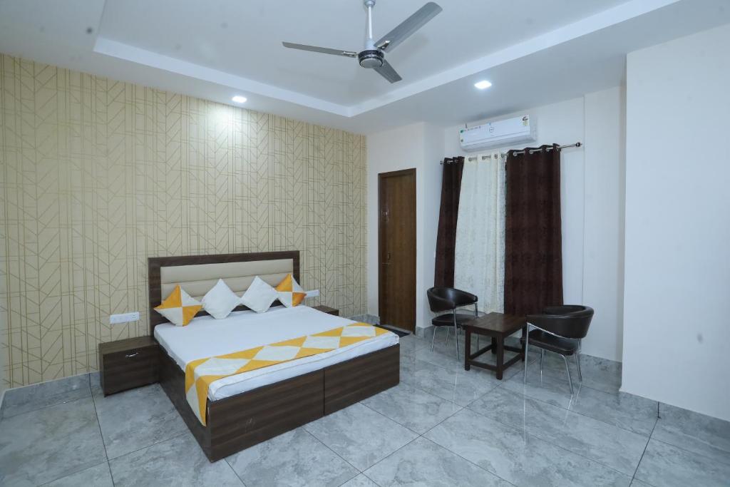 a bedroom with a bed and a desk and a chair at Raghav inn in Karnal