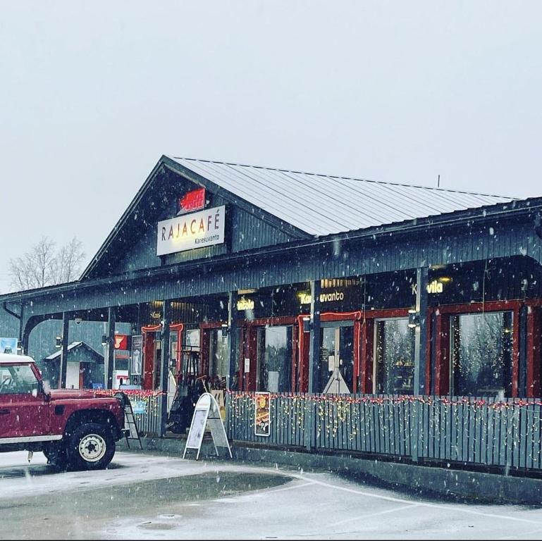 ein LKW, der vor einem Restaurant im Schnee parkt in der Unterkunft Wanha Tulli in Karesuvanto