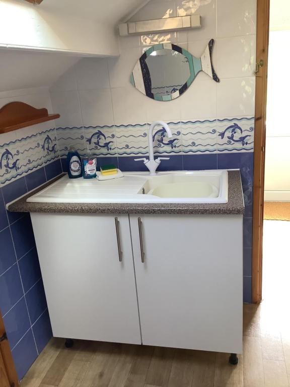 a kitchen with a sink and a mirror at Awel Y Mor - cosy apartment. in Verwick