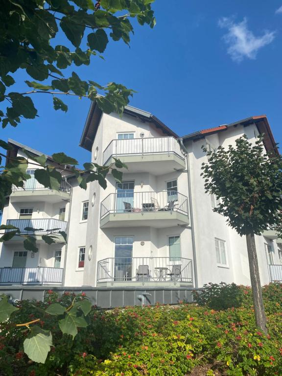 un edificio de apartamentos con balcones y un árbol en Ferienwohnung -STRANDNAH, en Ahlbeck