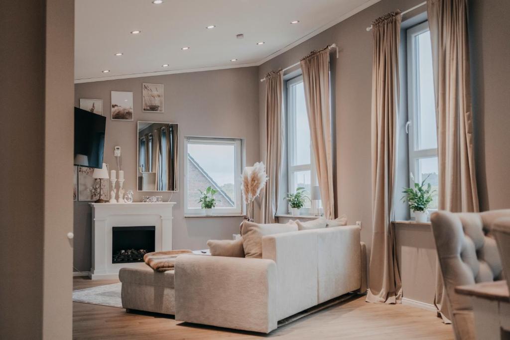 a living room with a white couch and a fireplace at Cottage an der Elbe Tespe Hamburg in Tespe