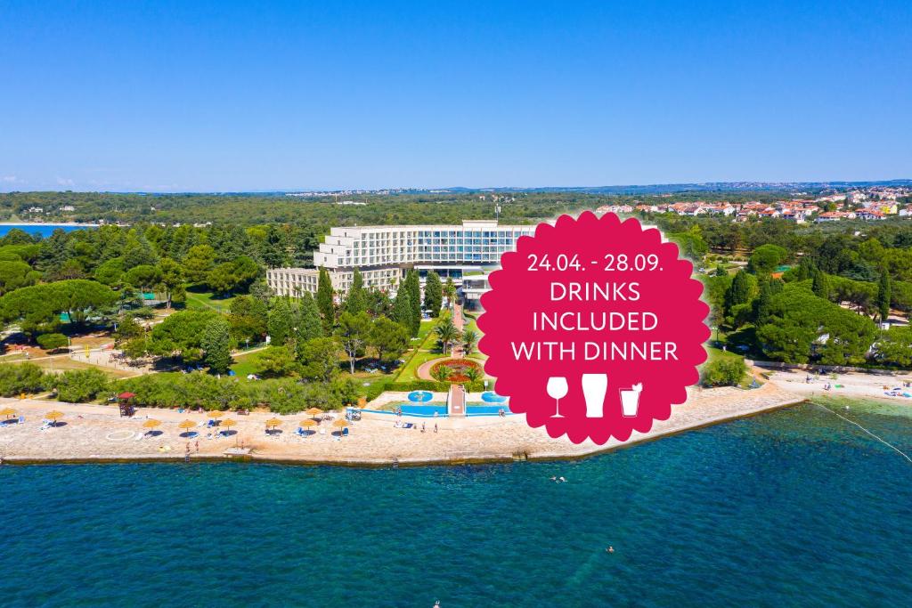an island in the water with a sign that reads drinks included with dinner at Hotel Materada Plava Laguna in Poreč