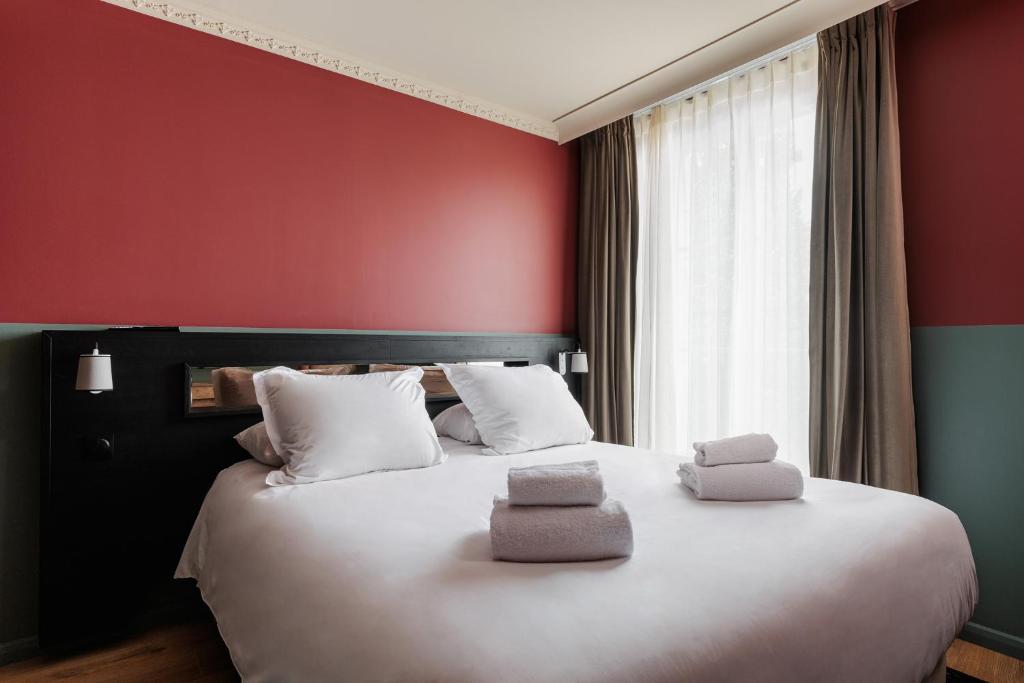 a bedroom with a large white bed with red walls at Arago - Entrée autonome, réception en ligne - Encore Mieux in Orléans