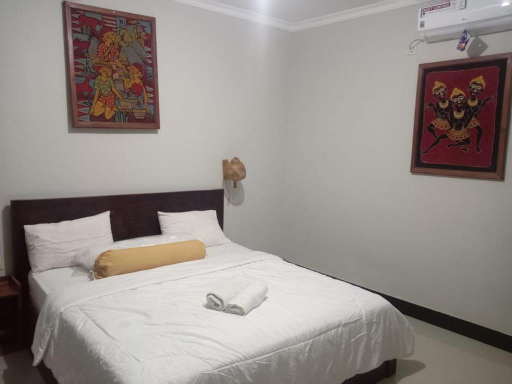 a bedroom with a bed with white shoes on it at Kri Homestay in Kuta Lombok