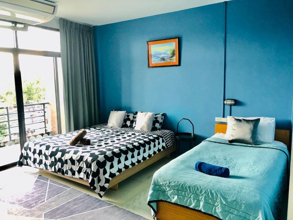 a bedroom with two beds and a blue wall at HOMEY-Don Mueang Airport Hostel in Bangkok
