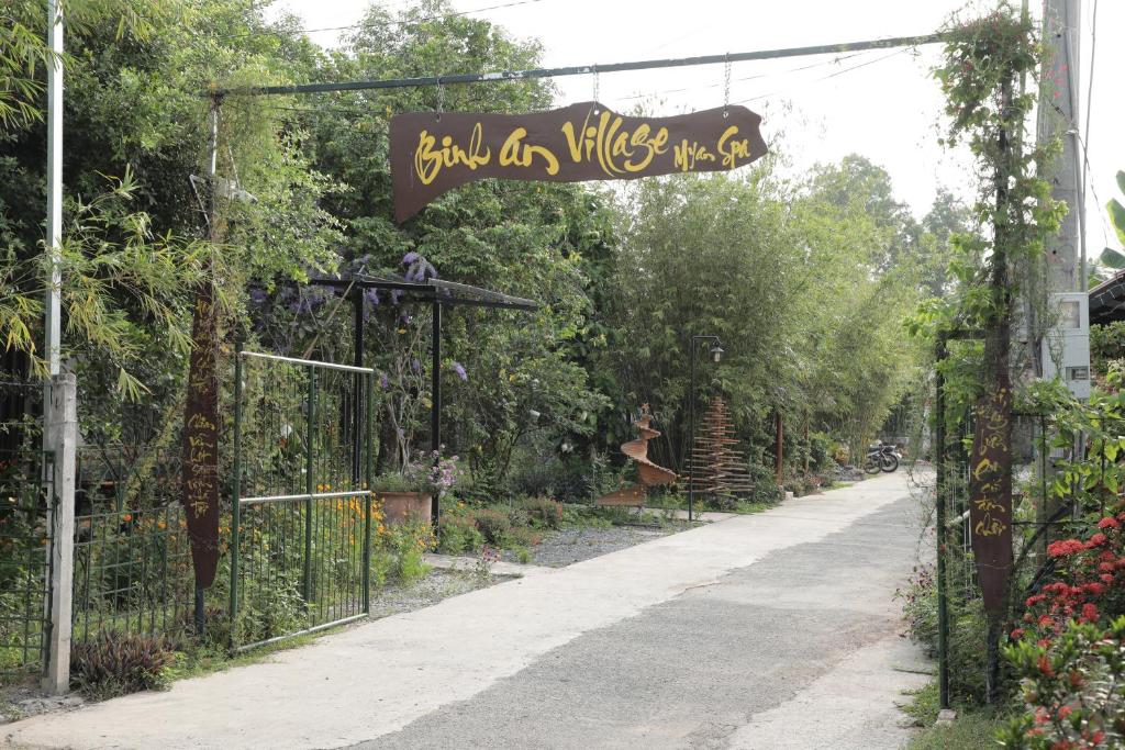ein Tor zu einem Garten mit einem Schild darauf in der Unterkunft Bình An Village in Vĩnh Long