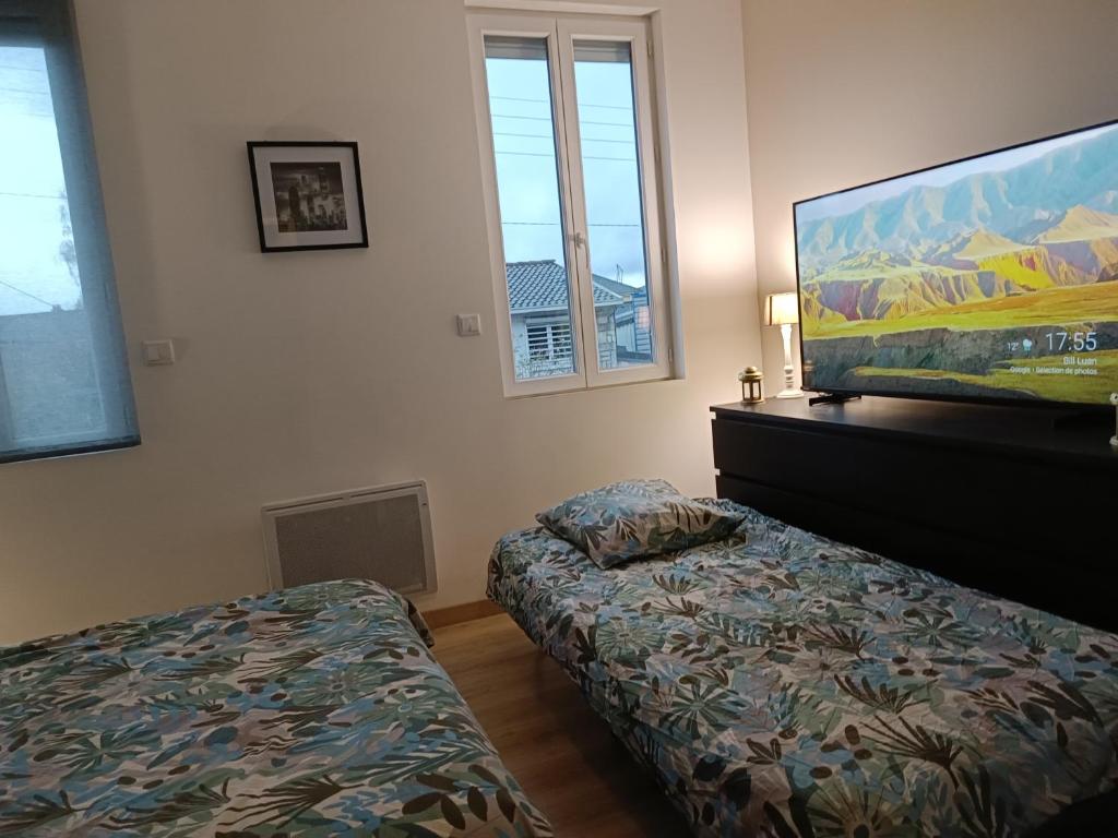 Schlafzimmer mit einem Bett und einem Flachbild-TV in der Unterkunft Maison de charme à Rouen Max 10 personnes in Rouen