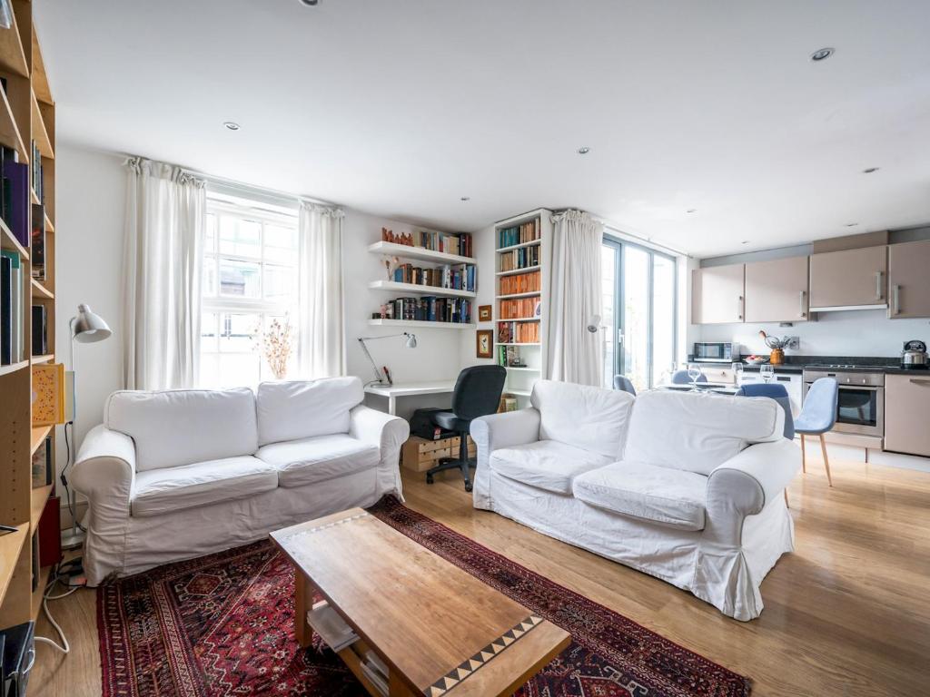 a living room with two white couches and a kitchen at Pass the Keys - Modern and spacious flat Near London Bridge in London