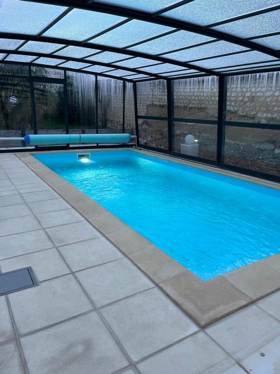 une grande piscine avec un toit dans l'établissement Gîte Laurymoor - Normandie, à Acquigny
