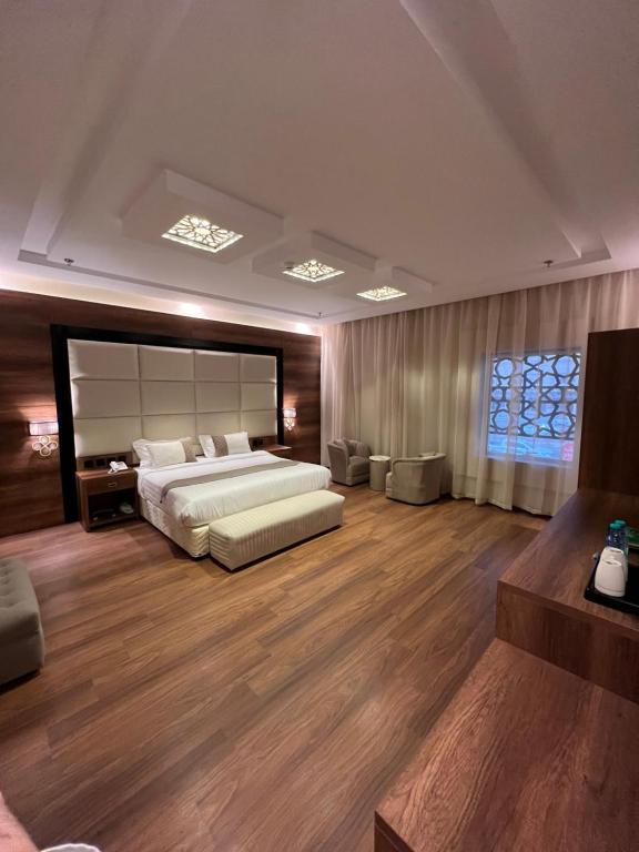 فندق الليالي الحالمة في المدينة المنورة: غرفة نوم كبيرة بسرير كبير وأرضيات خشبية