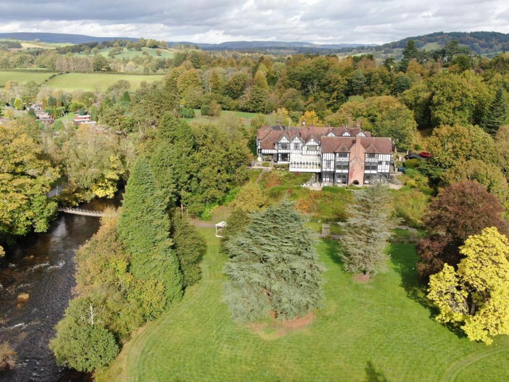 an aerial view of a large house next to a river at Caer Beris Manor By Group Retreats in Builth Wells