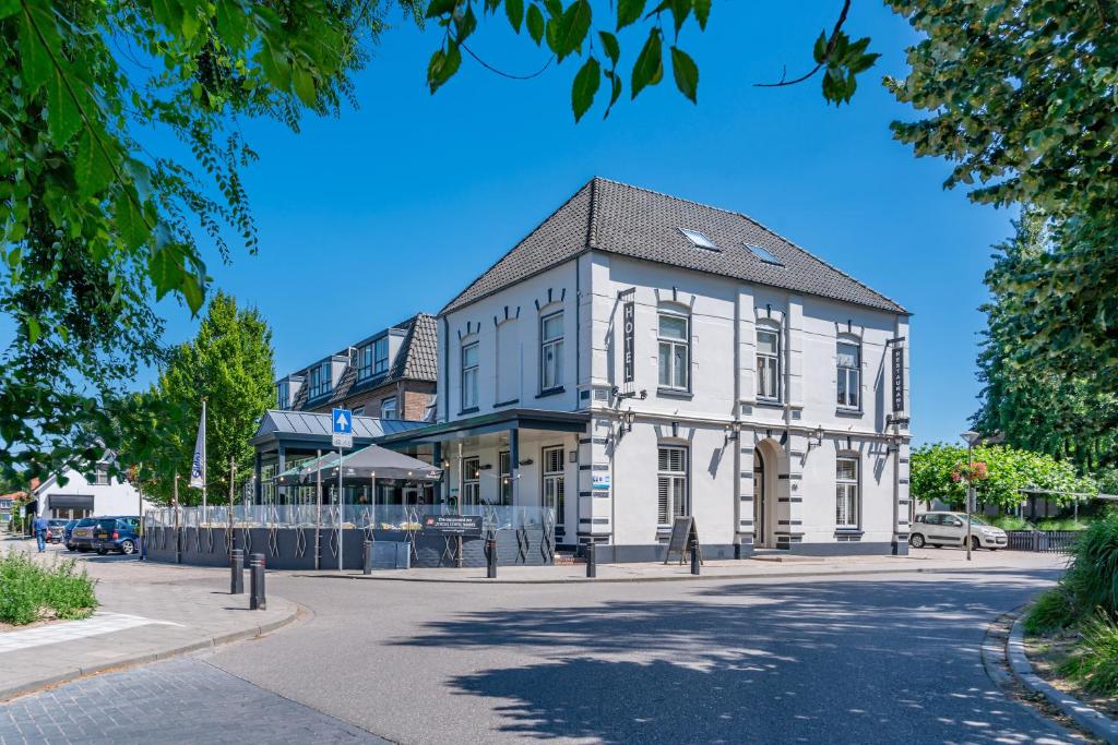 een wit gebouw aan de straatkant bij Hotel Millingen in Millingen aan de Rijn