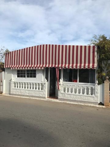 um edifício branco com um toldo vermelho e branco em casa movil em Playa Paraiso