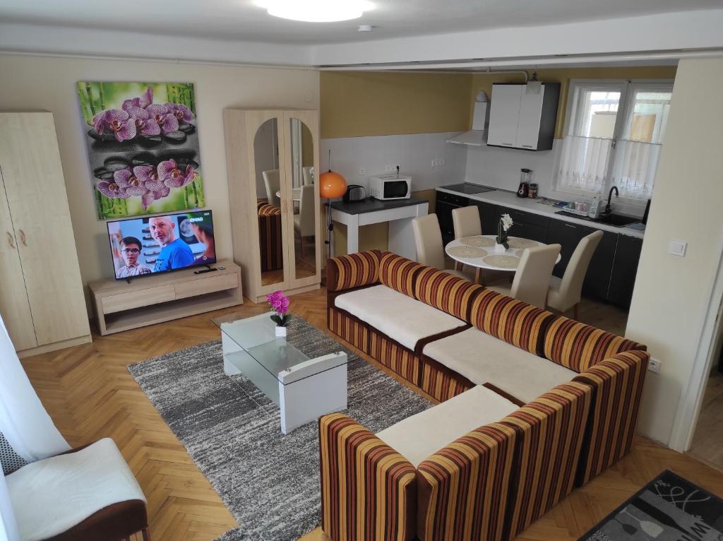 sala de estar con 2 sofás y cocina en SIESTA vendégház en Kiskunhalas