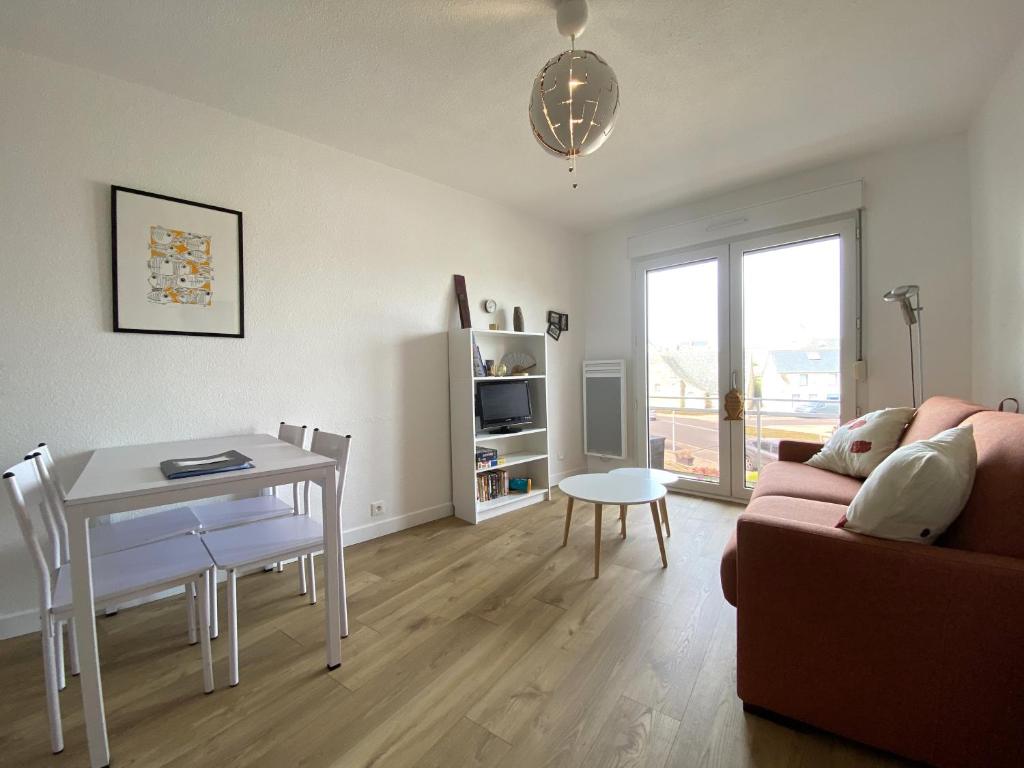 een woonkamer met een bank en een tafel en een eetkamer bij Appartement à 200m de la mer à TREGASTEL PLAGES - Réf 744 in Trégastel