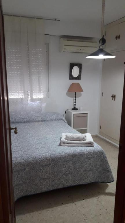 a bedroom with a bed with two towels on it at Habitaciones bonitas in Mairena del Aljarafe