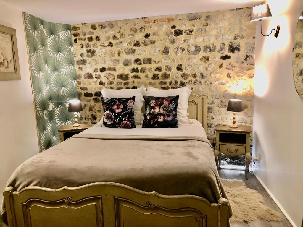 um quarto com uma cama com almofadas em Reglisse et Pain d'Epices - Chambres d'hôtes em Honfleur