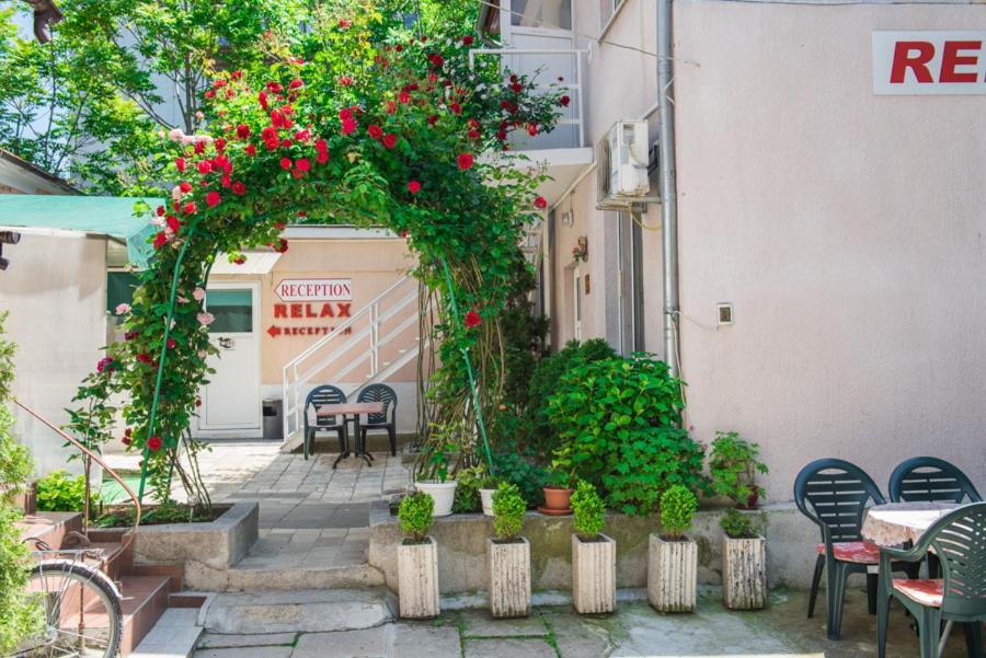 un patio esterno con tavoli, sedie e fiori di Стаи за гости a Varna