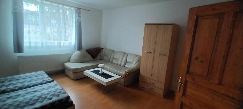 uma sala de estar com um sofá e uma mesa em Apartmán Robert em Kežmarok