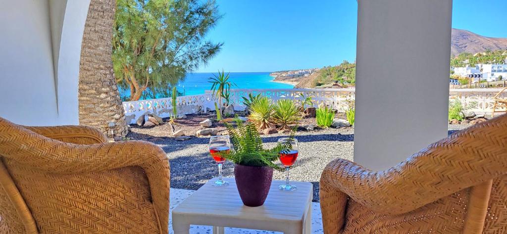 una mesa con dos copas de vino y un cactus en Casa Perrito Gris, en Playa de Jandía