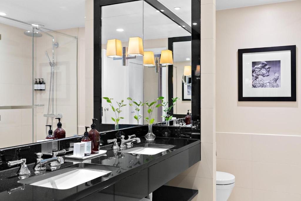 a bathroom with two sinks and a large mirror at Hotel Continental in Oslo