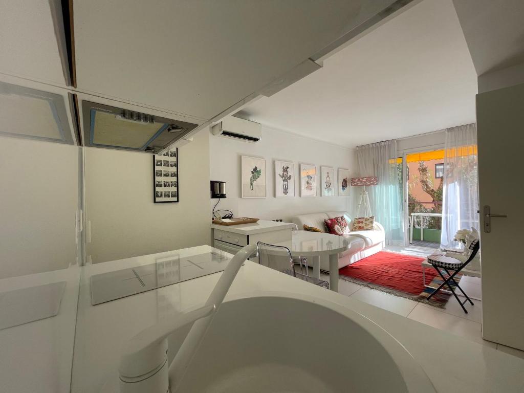 un salon blanc avec une table et un canapé dans l'établissement Renovated Cannes Centre Banane balcon, à Cannes