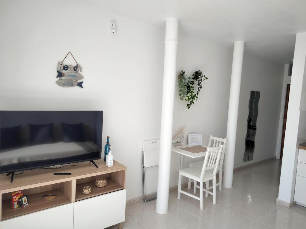 a living room with a flat screen tv and a table at Mirador de Sotavento apartment 103 in Costa Calma