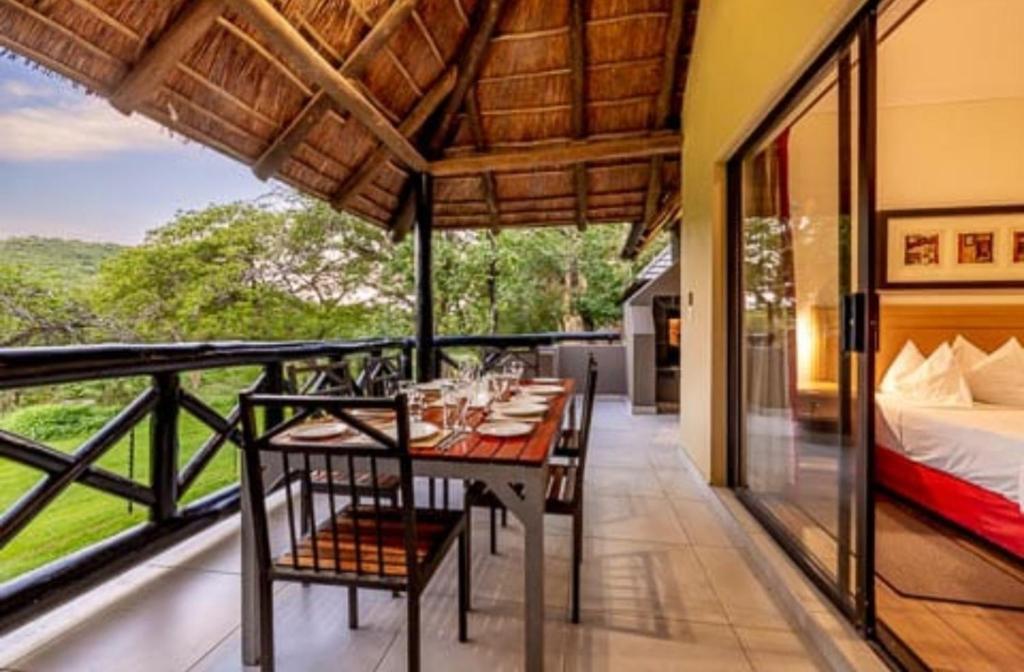 a dining room with a table and chairs on a balcony at Unit P11/29 Dec @Sanbonani Resort & Spa in Hazyview