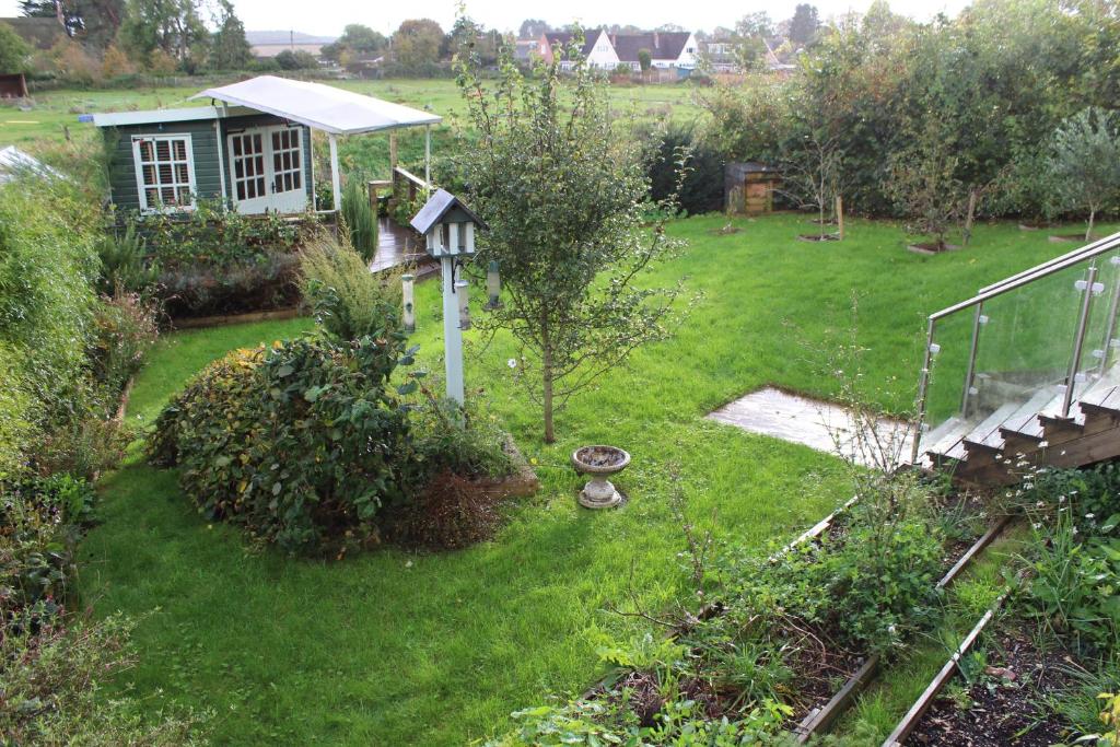 um jardim com uma casa de pássaros na relva em Beautiful Home in Dorset em Winterborne Kingston