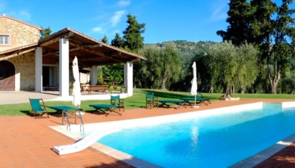 a swimming pool in front of a house at Nuvola - Villa Cenami - grande PISCINA con vista in Massarosa