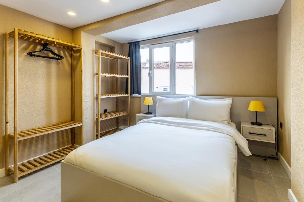 Un dormitorio con una gran cama blanca y una ventana en Studio Flat 6 min to Yedikule Fortress, en Estambul