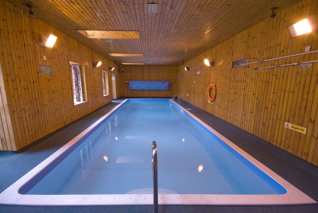 a large swimming pool in a wooden building at Courtyard Cottage in Tomich