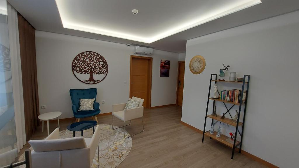 uma sala de estar com uma árvore na parede em DiROMANE em Braga