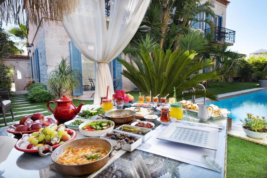 a buffet of food on a table next to a pool at Bramasole Alaçatı Butik Hotel in Alacati