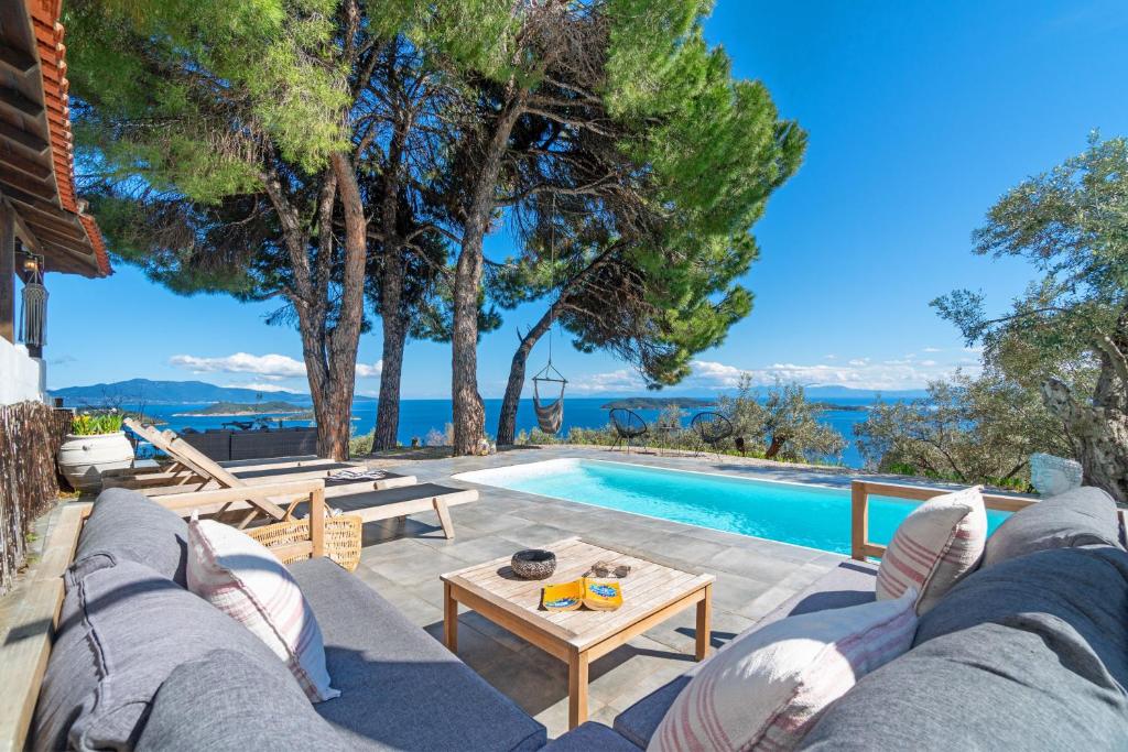 a patio with a couch and a table and a pool at Azul Boutique Home in Skiathos