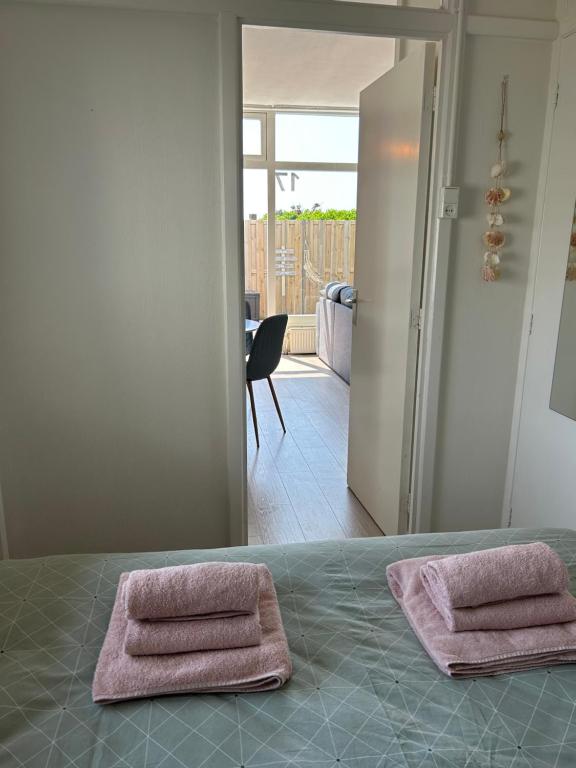 twee handdoeken zittend op een bed in een kamer bij Amsterdam Beach Apartment 17, incl Parking + Garden in Zandvoort