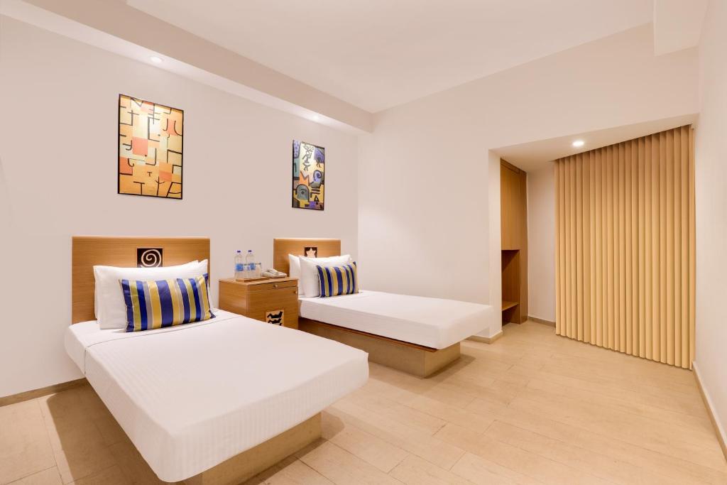 a hotel room with two beds and a window at Lemon Tree Hotel, Indore in Indore