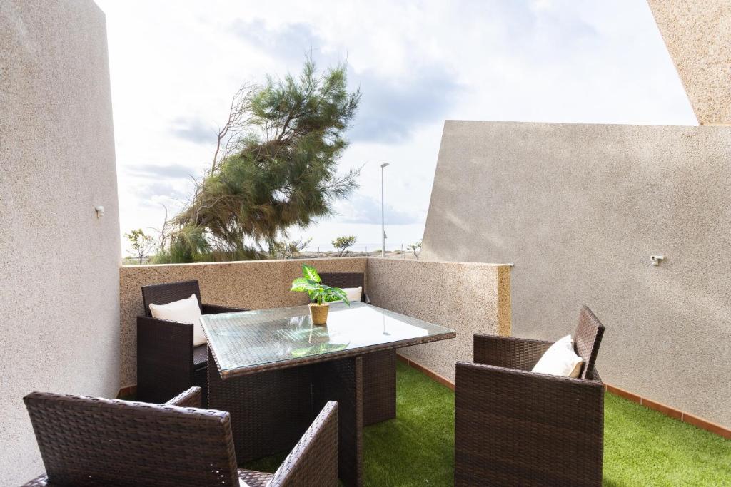 d'une terrasse avec une table et des chaises sur un balcon. dans l'établissement Family Sea View Townhouse, à El Médano