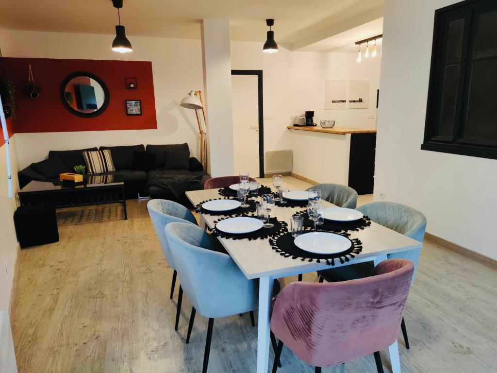 un soggiorno con tavolo e sedie blu di Appartement complet St Nolff 4 a Saint-Nolff