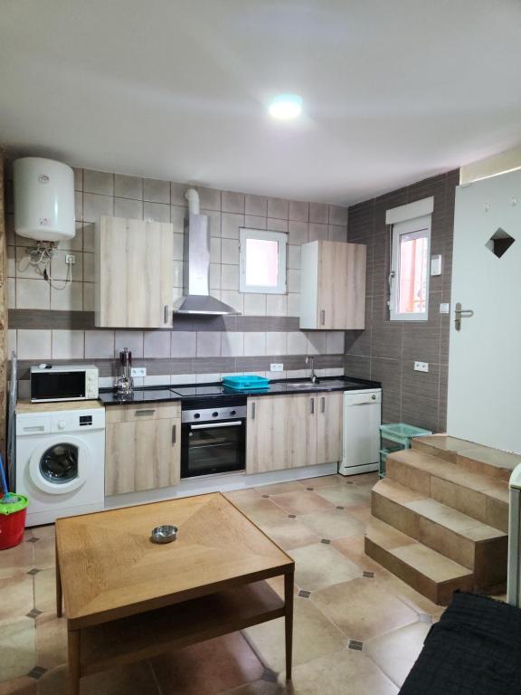 una cocina con electrodomésticos blancos y una mesa. en Casa económica Madrid, en Leganés